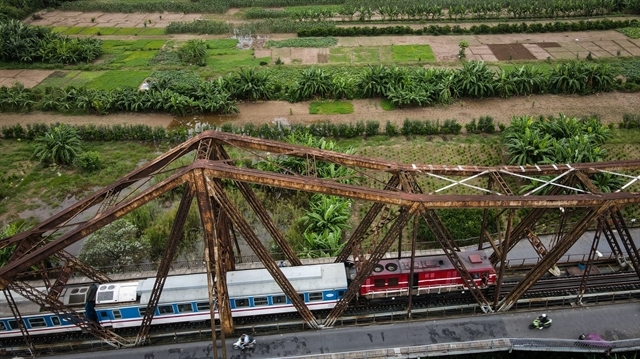 A train from northern Hải Phòng City crosses Long Biên Bridge in Hà Nội before entering Long Biên Railway Station on October 13. 