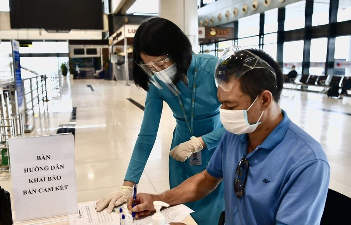 Hành khách đi máy bay làm thủ tục kê khai thông tin di chuyển nội địa để đảm bảo cho công tác phòng, chống dịch COVID-19. (Ảnh: CTV/Vietnam+)