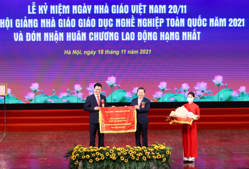 Ông Vũ Quang Trực, Phó Giám đốc Sở Lao động - Thương binh và Xã hội, nhận Cờ luân lưu đăng cai tổ chức Hội giảng Nhà giáo giáo dục nghề nghiệp năm 2024. 