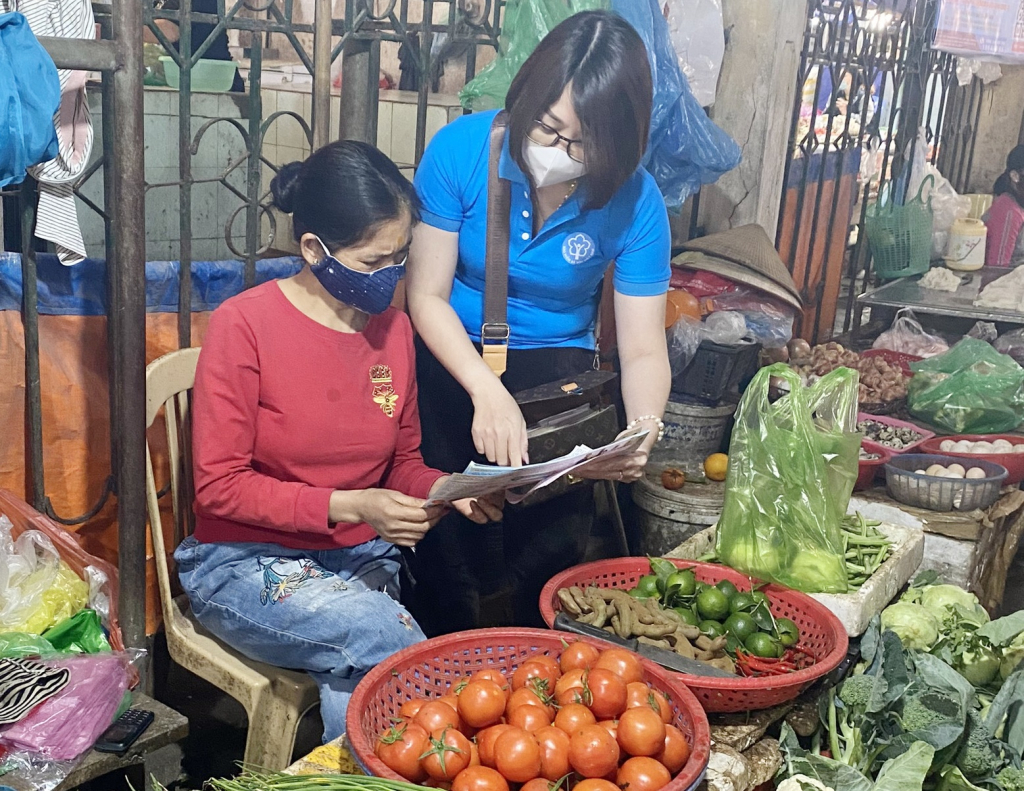 Cán bộ BHXH TX Quảng Yên vận động người dân tại các chợ dân sinh tham gia BHXH tự nguyện, BHYT hộ gia đình.