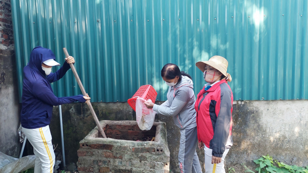 Chị Vũ Thị Lan, Chi hội trưởng Chi hội Phụ nữ khu Hồng Phong, phường Ninh Dương, Móng Cái cùng các hội viên trao đổi kỹ thuật phân loại rác, ủ phân vi sinh.