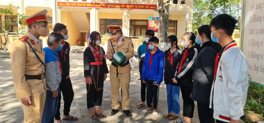 Cán bộ Đội CSGT huyện Ba Chẽ hướng dẫn các em học sinh trong đội tự quản giao thông Trường THCS Dân tộc nội trú huyện Ba Chẽ về cách nhận biết mũ bảo hiểm đạt tiêu chuẩn