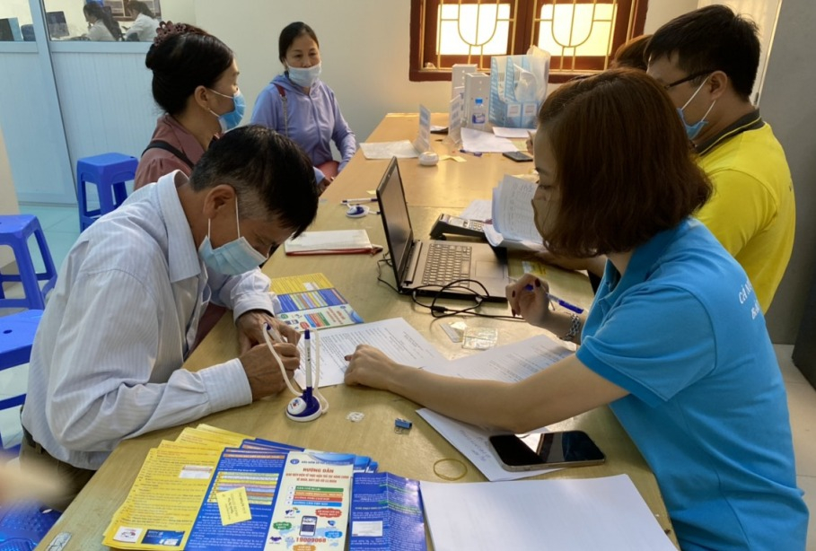 Cán bộ, nhân viên BHXH huyện Tiên Yên làm thủ tục tham gia BHXH, BHYT cho người dân.