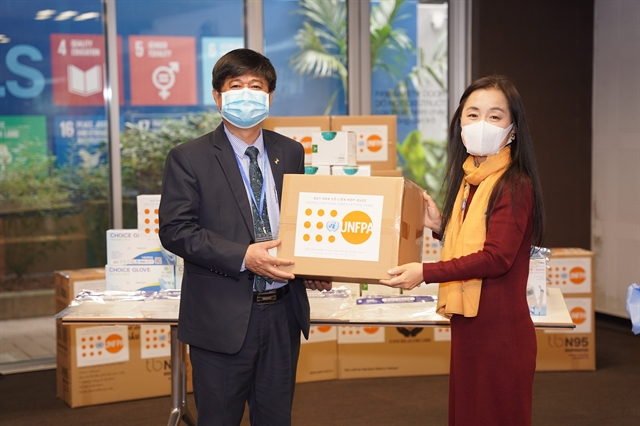 Naomi Kitahara, UNFPA Representative in Việt Nam, presents the medical supplies to the Vietnamese health ministry. 