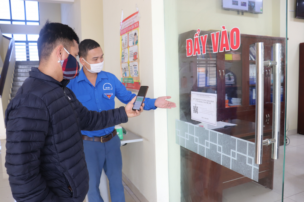 Cán bộ đoàn thanh niên của xã Thống Nhất (TP Hạ Long) hướng dẫn người dân quét mã QR code khi đến làm việc tại trụ sở xã.