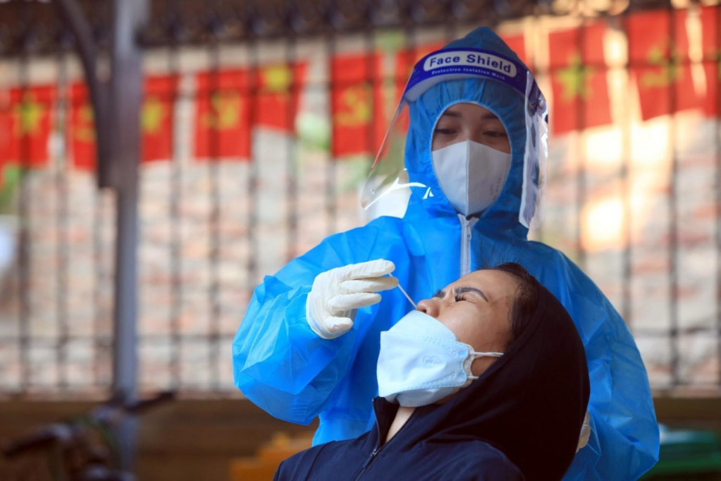 A medical worker takes a COVID-19 testing sample in Tam Hiệp Commune, Thanh Trì District, Hà Nội.