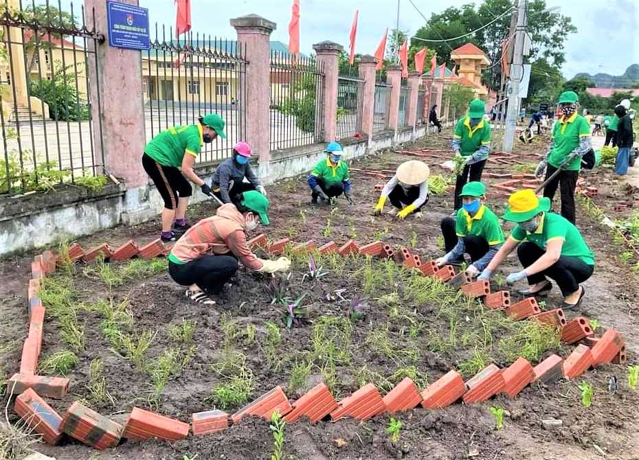 Cán bộ, hội viên phụ nữ xã Hạ Long (huyện Vân Đồn) tham gia trồng tuyến đường hoa kiểu mẫu.