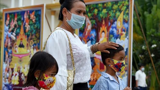 People wear face masks to avoid COVID-19 infection in Phnom Penh in May 2020. (Photo: AFP/VNA)