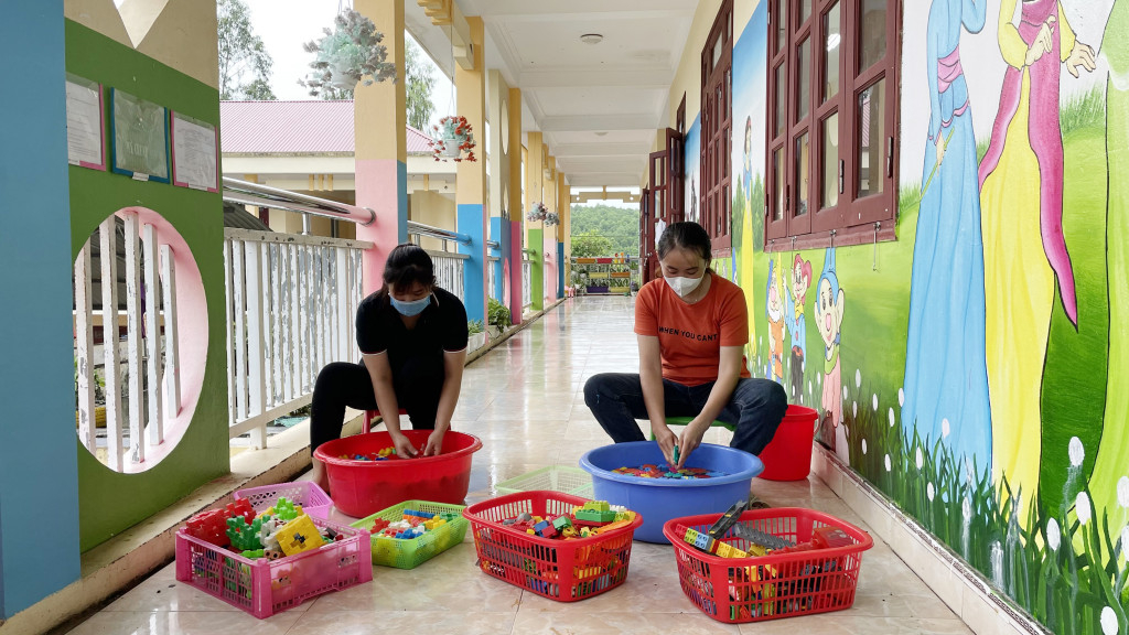 Các cô giáo Trường Mầm non Đông Hải, huyện Tiên Yên vệ sinh trang thiết bị, đồ dùng, đồ chơi cho trẻ. Ảnh: Lan Anh