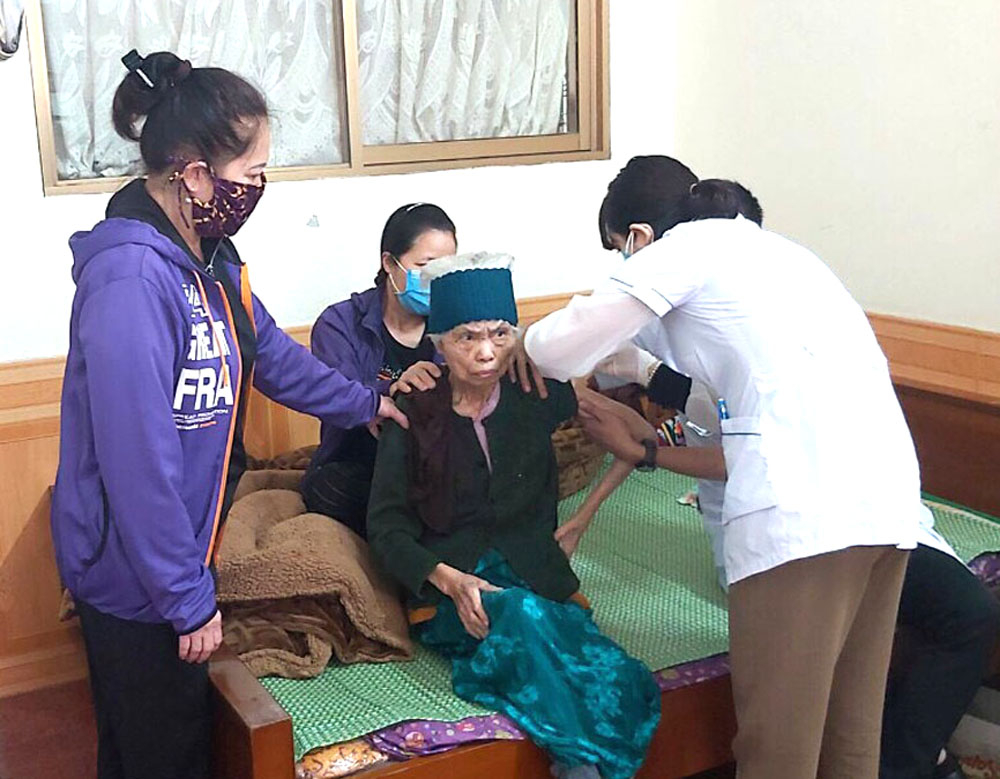Đội tiêm phòng lưu động Covid-19 tại nhà thực hiện tiêm phòng cho một người già ở phường Cửa Ông, TP Cẩm Phả