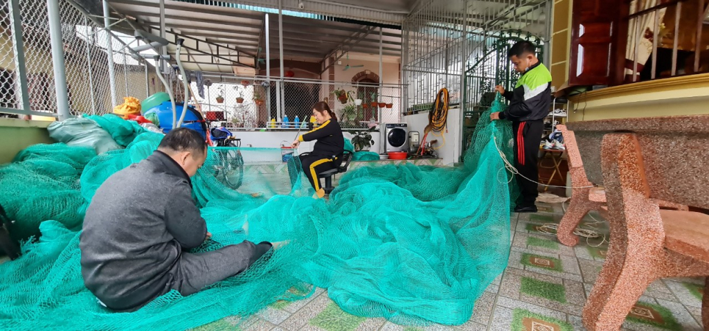  Gia đình ông Vũ Văn Mạnh đan lại giàn lưới để chuẩn bị cho chuyến ra khơi đầu năm.