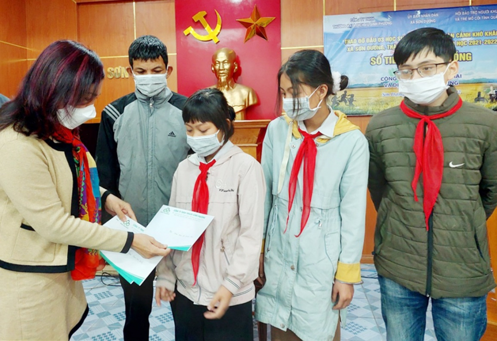 Bà Đào Kim Phượng, Giám đốc Công ty TNHH Thương mại và Dịch vụ Sinh Phượng trao đỡ đầu cho các em học sinh mồ côi, hoàn cảnh khó khăn.