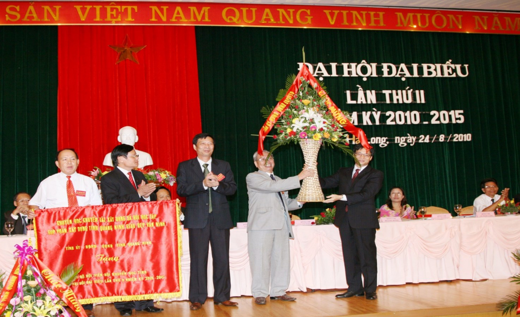  Đồng chí Vũ Đức Đam, Bí thư tỉnh uỷ (người ngoài cùng bên phải) tặng hoa và bức trướngmmang dòng chữ “Khuyến học, khuyến tài xây dựng xã hội học tập góp phần xây dựng tỉnh Quảng Ninh giàu đẹp văn minh” cho Ban chấp hành Hội Khuyến học tỉnh.