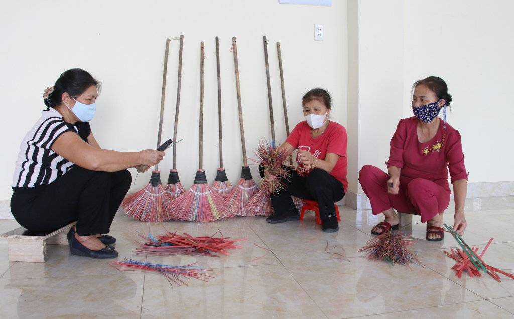 Bà Lê Thị Minh Huệ (bên trái) cùng thành viên Tổ đan chổi tái chế chẻ dây đan chổi.
