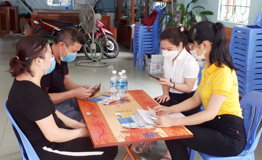 Cán bộ BHXH tỉnh và Bưu điện tỉnh hướng dẫn người dân phường Trần Hưng Đạo (TP Hạ Long) tham gia BHXH tự nguyện.