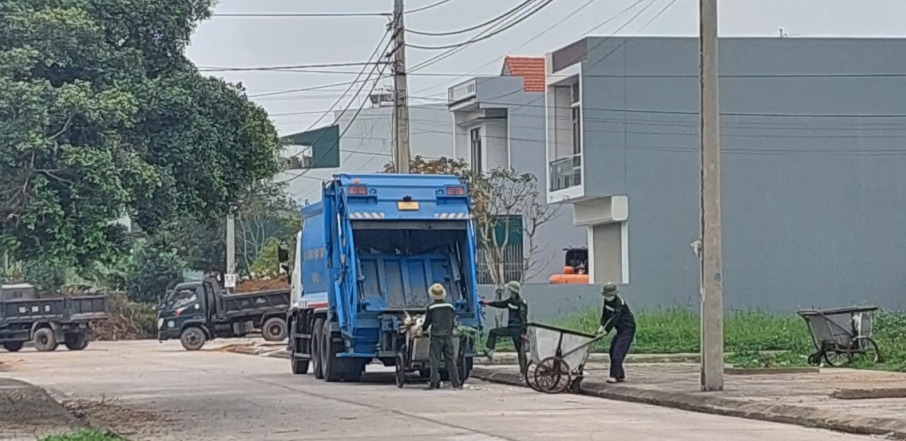 Công nhân Công ty TNHH Xây dựng và Thương mại dịch vụ Bảo Linh thu gom rác thải sinh hoạt tại phố Ngô Quyền, thị trấn Quảng Hà (Hải Hà).