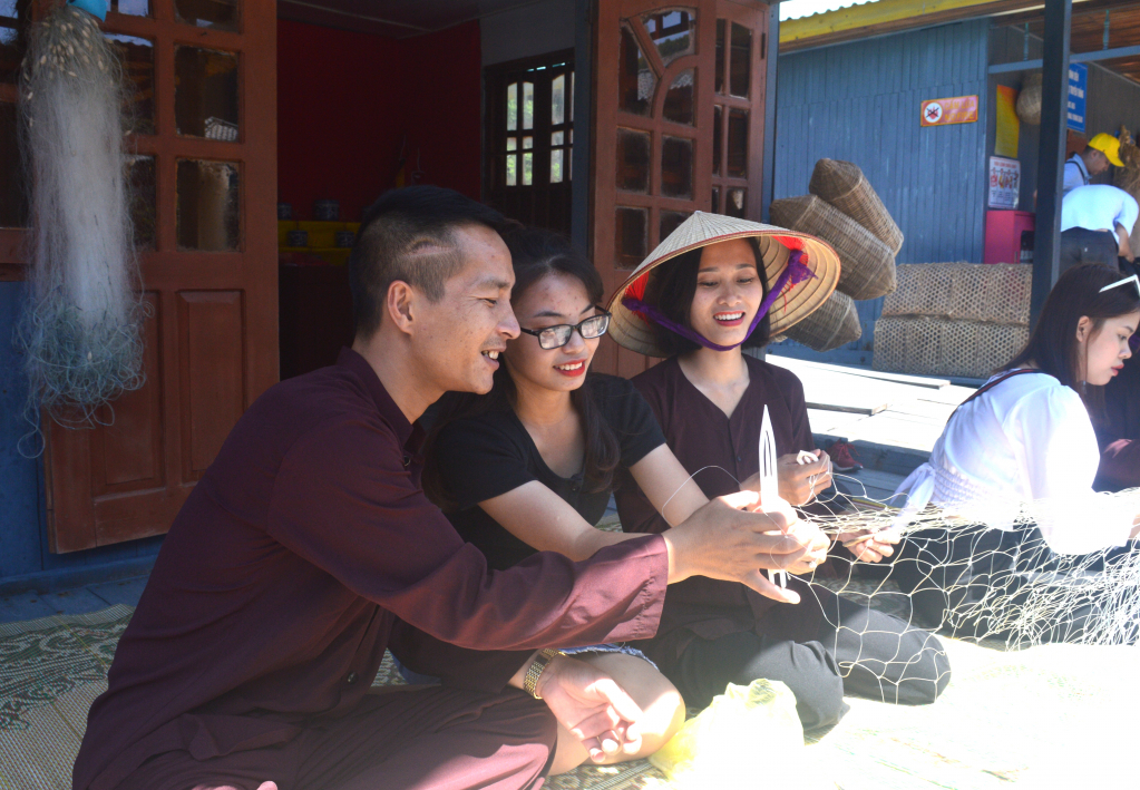 Du khách trải nghiệm đan lưới tại làng chài Vung Viêng trên vịnh Hạ Long.