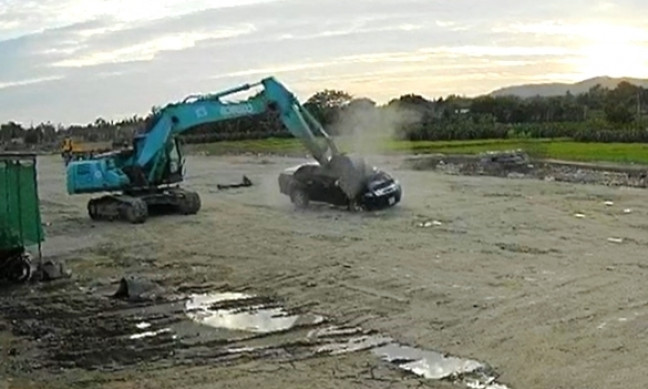 Lái xe cuốc đập nát hai ôtô trên công trường