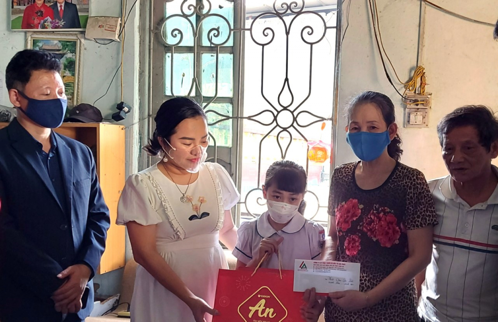 Quỳnh Anh cùng ông bà ngoại nhận quà tặng của một doanh nghiệp