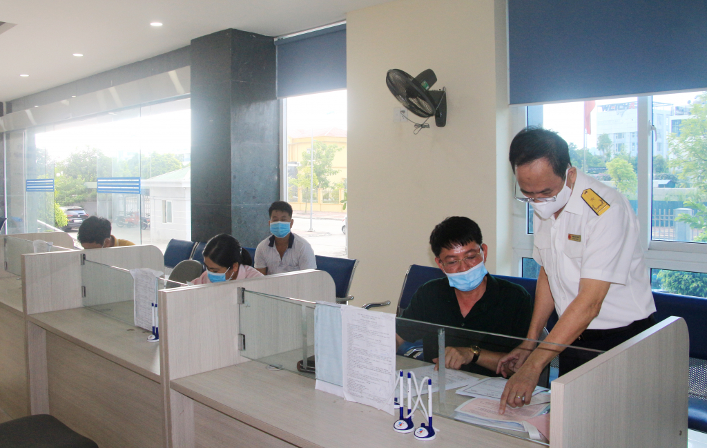Cán bộ Chi cục Thuế khu vực Cẩm Phả - Vân Đồn - Cô Tô hỗ trợ doanh nghiệp, người dân kê khai nộp thuế. 