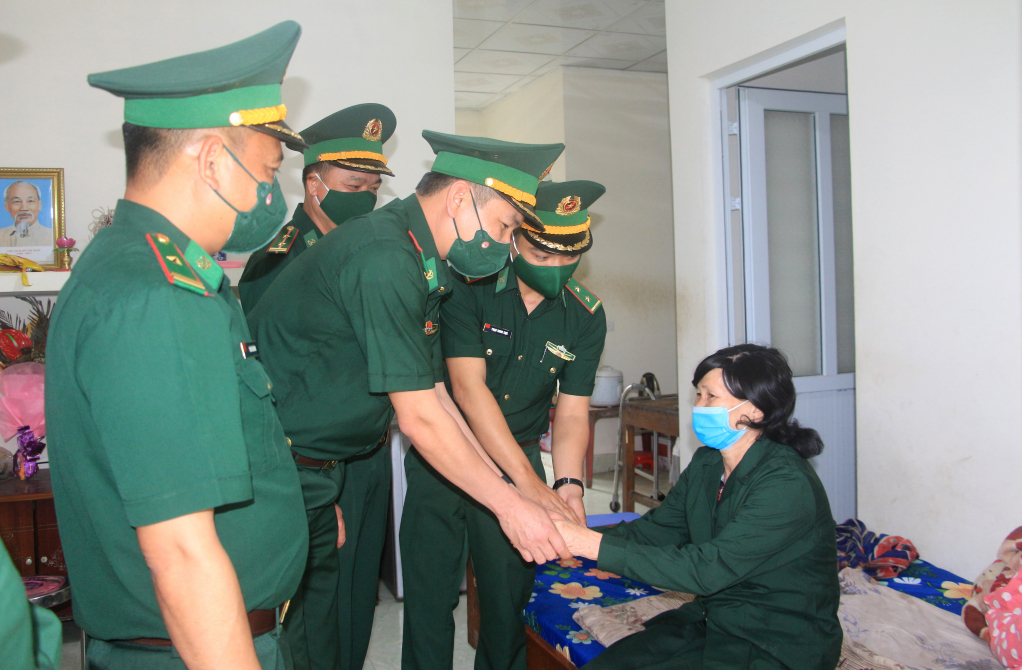 Cán bộ, chiến sĩ Đồn Biên phòng Pò Hèn động viên, thăm hỏi gia đình bà Trần Thị Tay, Hội viên Hội thanh niên xung phong xã Hải Sơn. Ảnh: Mạnh Trường