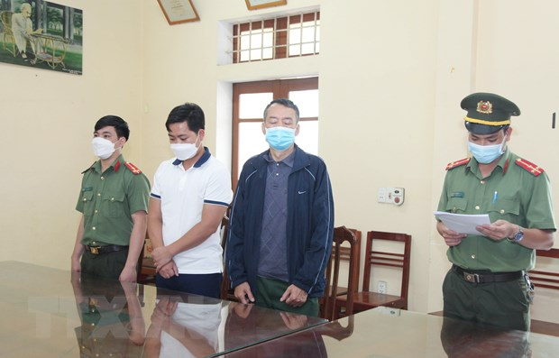 Cơ quan An ninh điều tra đọc lệnh bắt tạm giam đối tượng Khánh và An. (Ảnh: Hoàng Nguyên/TTXVN)