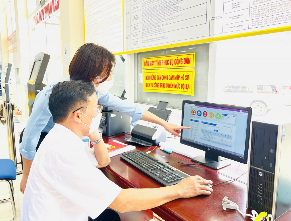 Cán bộ Trung tâm Hành chính công thị xã Đông Triều hướng dẫn người dân thực hiện dịch vụ công trên mạng.