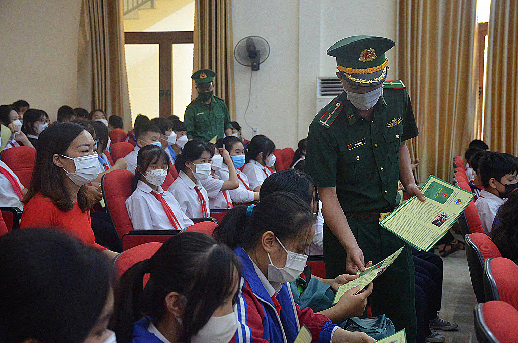 Cán bộ Trạm Biên phòng Hà An phát tờ rơi tuyên truyền Luật Biên phòng cho học sinh Trường THCS Hà An (TX Quảng Yên)