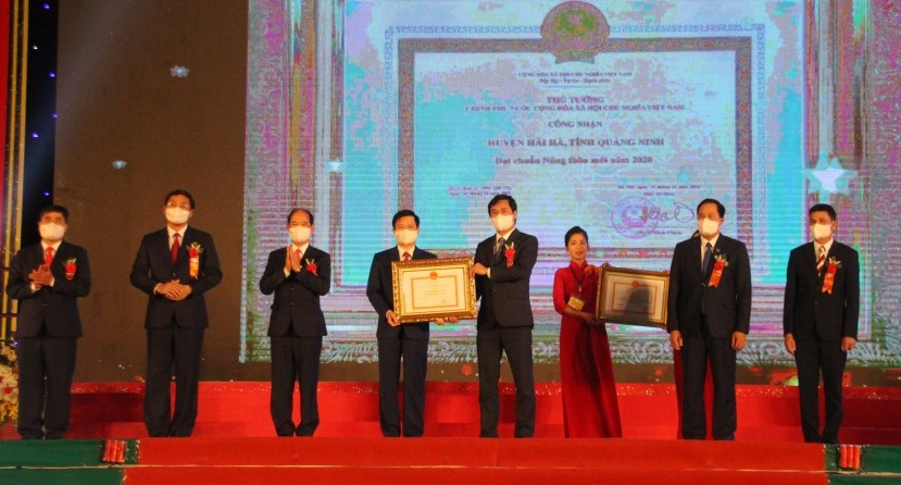 Thừa uỷ quyền, đồng chí Nguyễn Tường Văn, Chủ tịch UBND tỉnh trao bằng công nhận của Thủ tướng Chính phủ công nhận huyện đạt chuẩn huyện NTM năm 2020 cho cán bộ, nhân dân huyện Hải Hà.