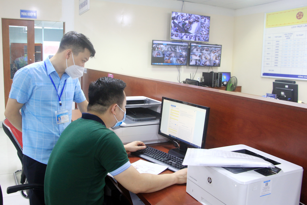Cán bộ Trung tâm HCC TP Hạ Long hỗ trợ người dân kê khai nộp TTHC trực tuyến.