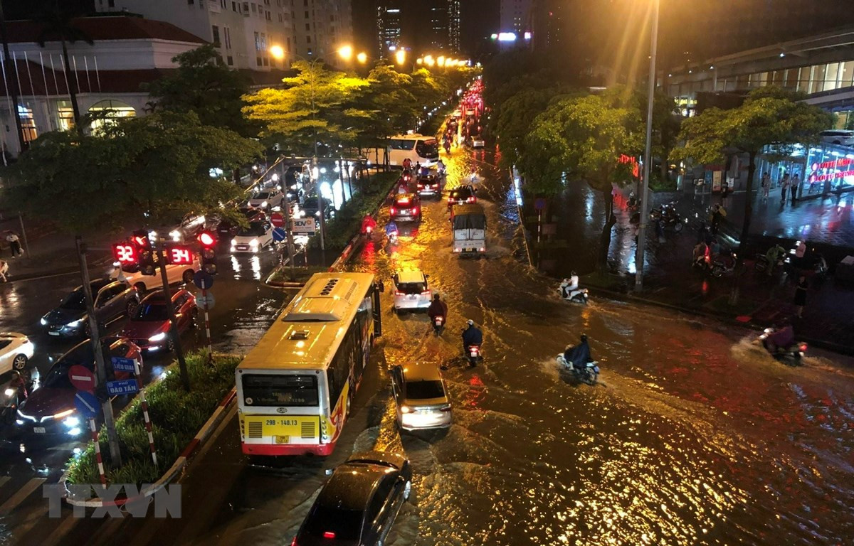 Mưa lớn gây ngập úng tại phố Đào Tấn, khiến các phương tiện lưu thông khó khăn. (Ảnh: Huy Hùng/TTXVN)