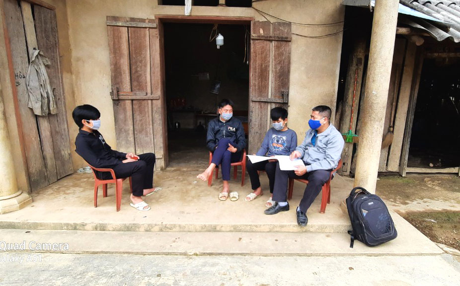 Thầy Hoàng Văn Pẩu (bên phải) trong một buổi đến thôn Khe Vang để vận động học sinh trở lại trường