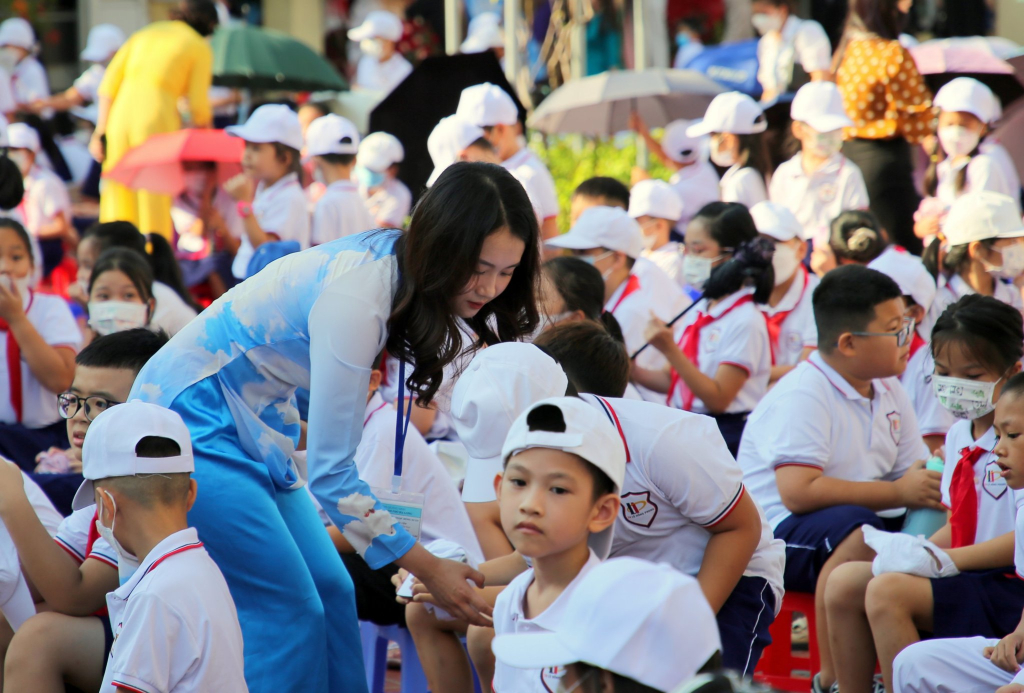 Các cô giáo trường Tiểu học Lê Hồng Phong ân cần hướng dẫn chỗ ngồi cho các em học sinh, đảm bảo trật tự trong quá trình khai giảng.