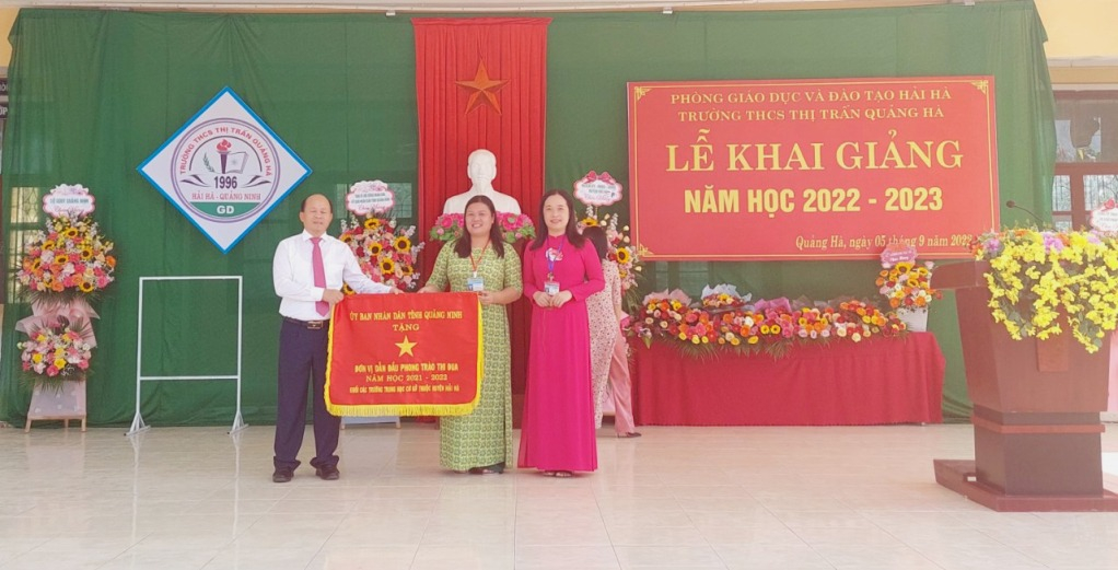 Đồng chí Vũ Xuân Diện trao cờ đơn vị dẫn đầu phong trào thi đua năm học 2021-2022 của UBND tỉnh cho Trường THCS thị trấn Quảng Hà