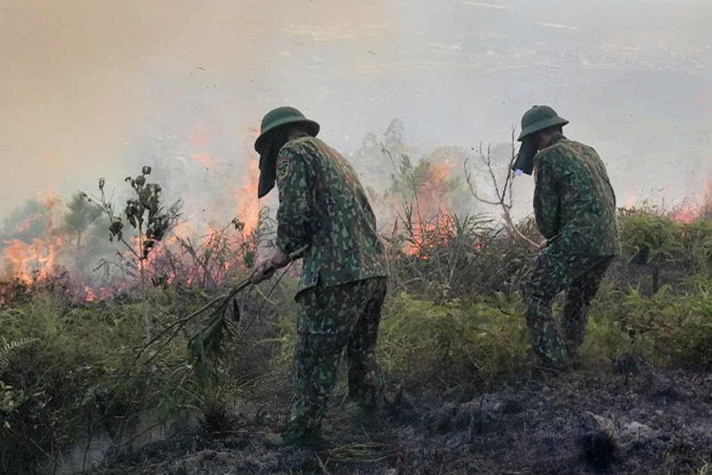 Cán bộ, chiến sĩ Ban CHQS TP Uông Bí phối hợp cùng các lực lượng dập tắt đám cháy.