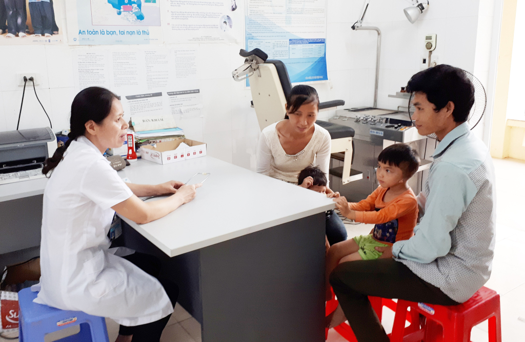 ác sĩ Trạm Y tế xã Đồn Đạc (huyện Ba Chẽ) hướng dẫn, tư vấn cho cha mẹ về cách phòng bệnh cho con.