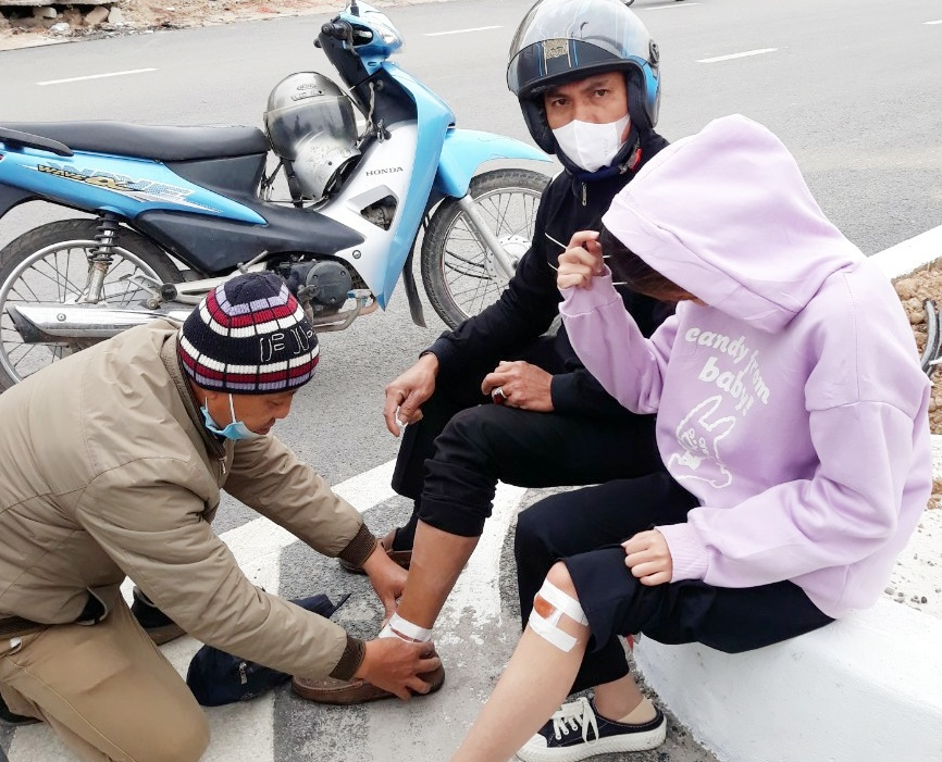Ông Vũ Bá Hùng, Đội trưởng Đội xe ôm Thân thiện- An toàn điểm chốt chợ Rọc (phường Quảng Yên, TX Quảng Yên) đang băng bó vết thương cho nạn nhân bị tai nạn xe máy đầu năm 2022.
