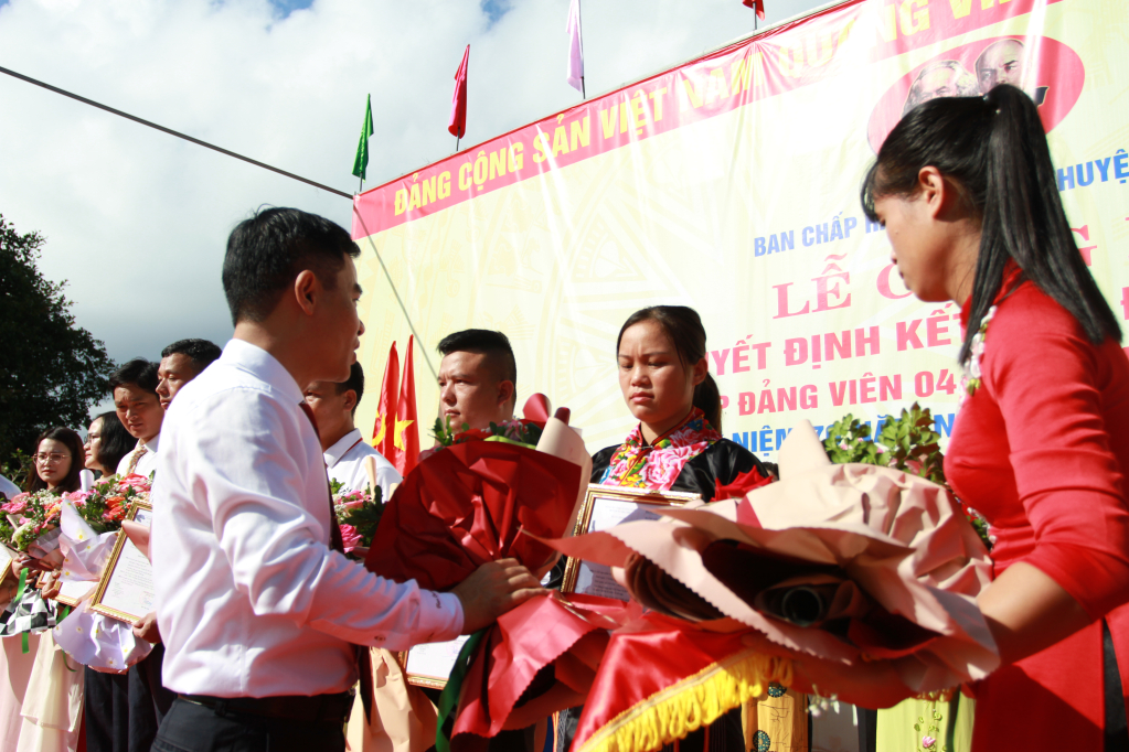 Lãnh đạo huyện tặng hoa chúc mừng các đảng viên mới.