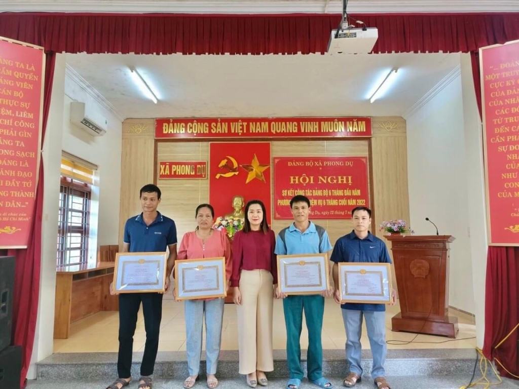 Đồng chí La Thị Thủy (đứng giữa), Bí thư Đảng ủy, Chủ tịch UBND xã Phong Dụ (huyện Tiên Yên) trao giấy khen của UBND xã cho các