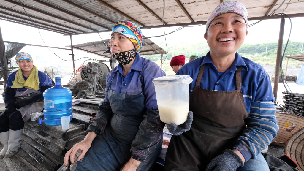 Chị Nguyễn Thị Nhàn - phụ trách công đoàn tổ vừa vui đùa, vừa “khoe” bình cháo trắng mang ở nhà ra dùng trong giờ nghỉ giải lao.