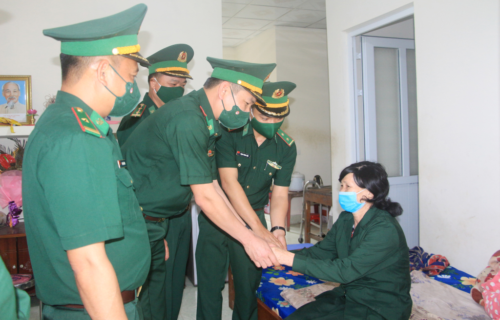 Thiếu tá Vũ Văn Lương và cán bộ, chiến sĩ Đồn Biên phòng Pò Hèn thăm hỏi bà Trần Thị Tay - Cựu thanh niên xung phong, công nhân Lâm trường Hải Sơn.
