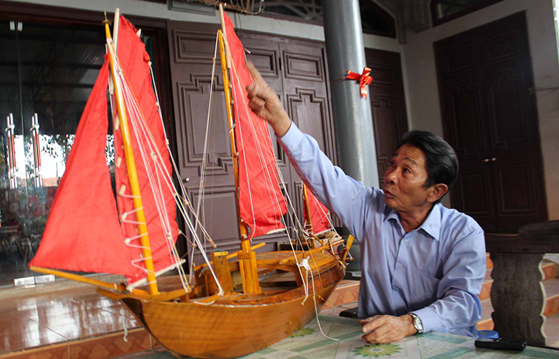 Ông Lê Đức Chắn giới thiệu mô hình thuyền vỏ gỗ, buồm cánh dơi có thể chạy ngược nước, ngược gió.
