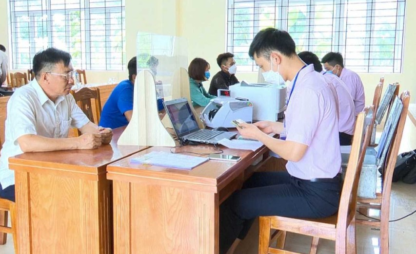 Cán bộ Ngân hàng CSXH huyện Hải Hà tổ chức giải ngân cho người dân tại điểm giao dịch trụ sở UBND xã Quảng Thành