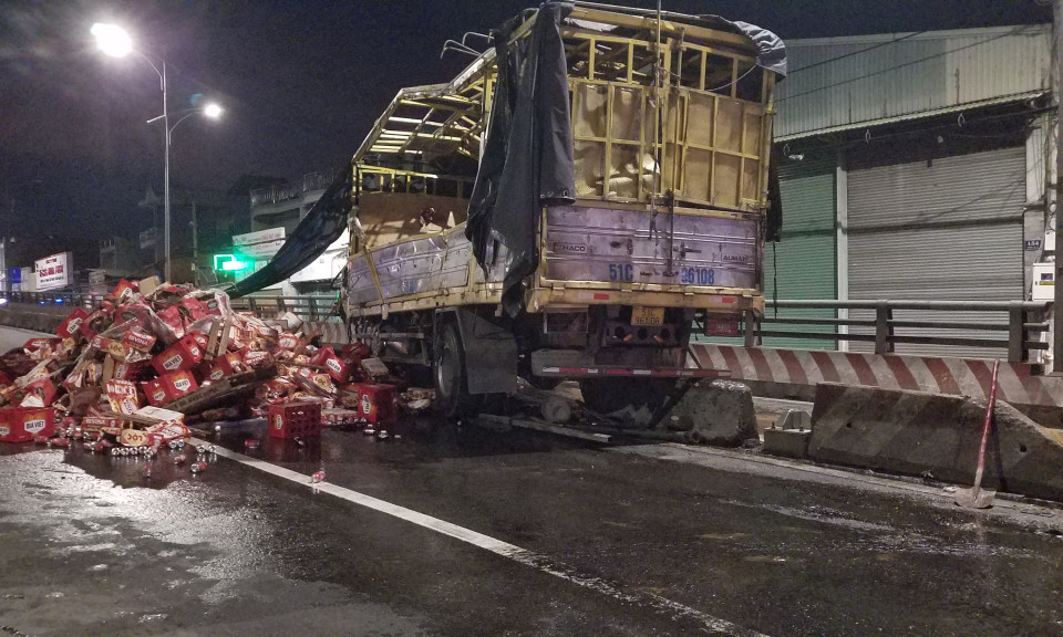 Xe tải lật trên quốc lộ 1, hàng trăm thùng bia đổ ra đường