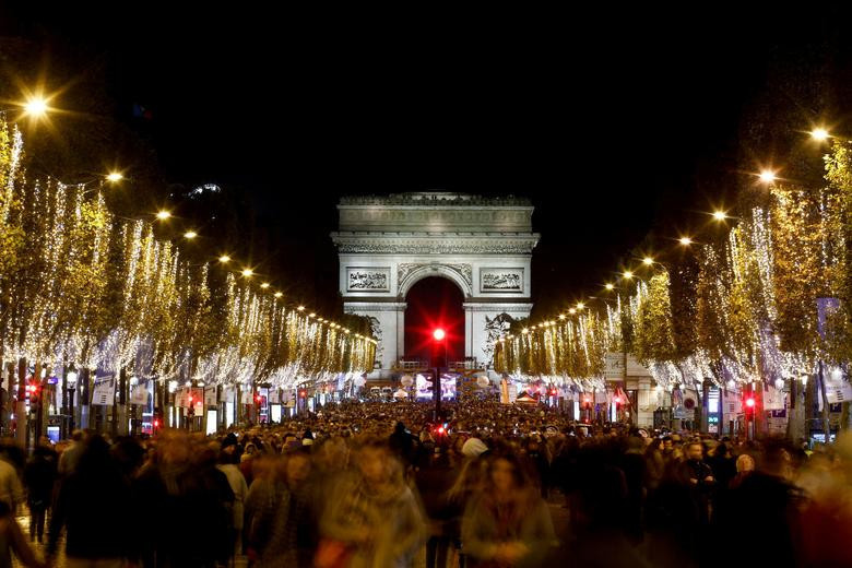 Người dân tham dự lễ ra mắt đèn ngày lễ Giáng sinh dọc theo đại lộ Champs-Elysees với Khải Hoàn Môn ở Paris, Pháp.