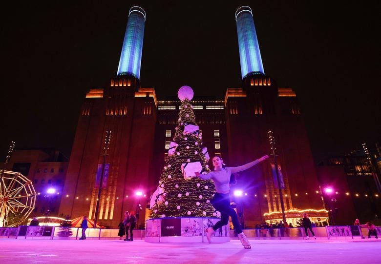 Người dân trượt băng trên sân trượt băng 'Glide at Battersea Power Station' bên ngoài Nhà máy điện Battersea mới được tân trang lại ở London, Anh.