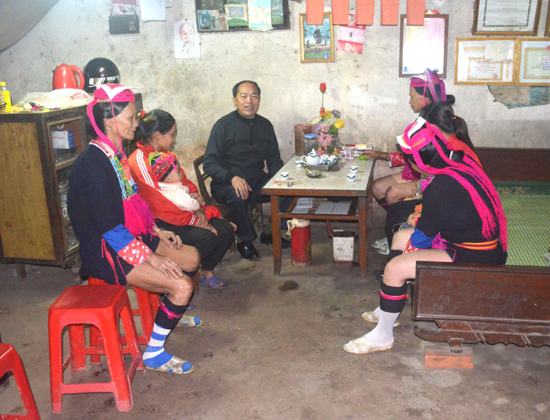 Ông Choóng Sau Quay, người có uy tín ở thôn Khe Mươi, xã Đại Thành (Tiên Yên), trò chuyện với người dân về việc giữ gìn an ninh trật tự ở xã. Ảnh Công Thành