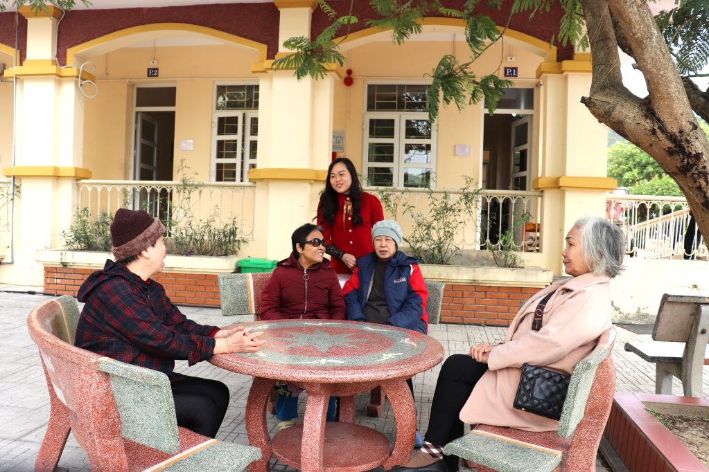 Cán bộ Trung tâm bảo trợ xã hội tỉnh Quảng Ninh trò chuyện với người cao tuổi trong trung tâm. 