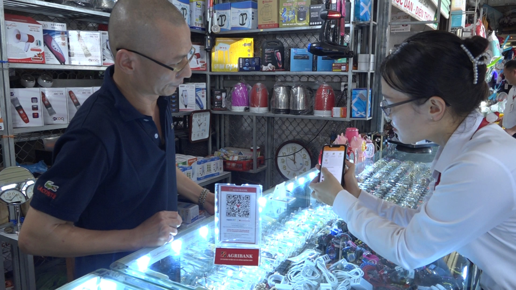 Cán bộ Ngân hàng NN&PTNT huyện Hải Hà hướng dẫn chủ cửa hàng thực hiện thanh toán không dùng tiền mặt