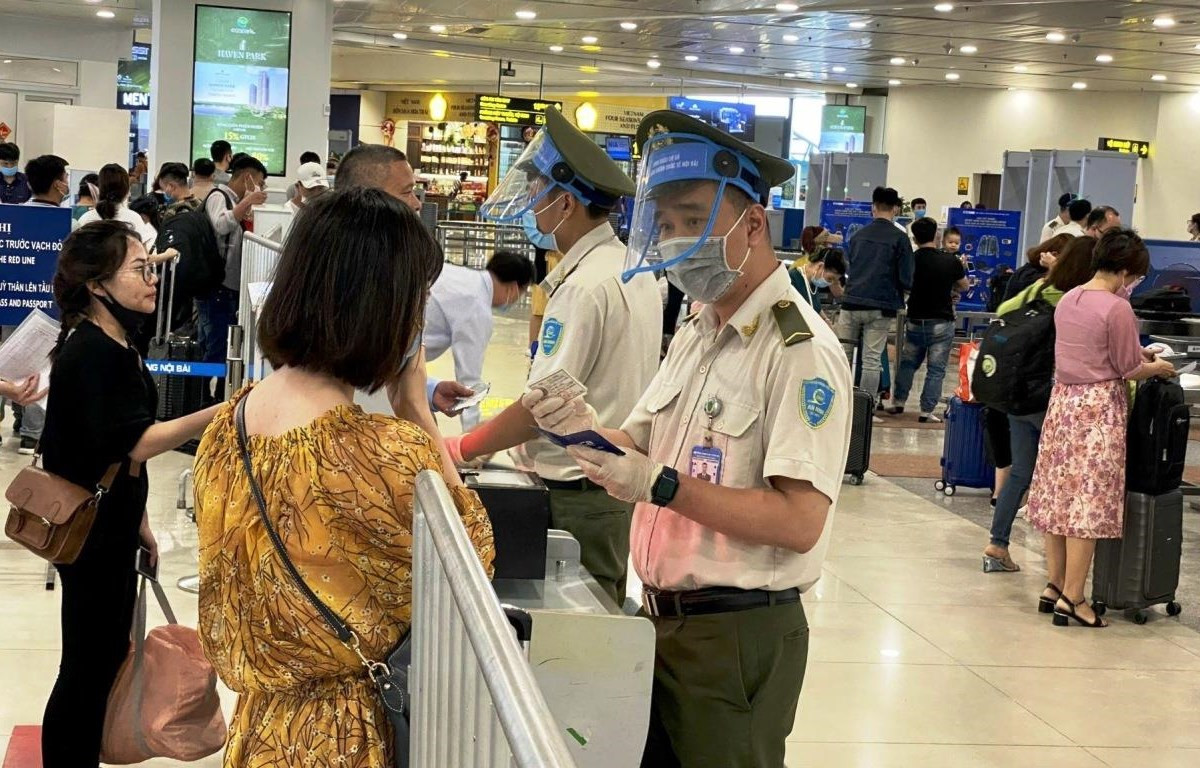 Nhân viên an ninh hàng không kiểm tra giấy tờ hành khách đi máy bay. (Ảnh: CTV/Vietnam+)